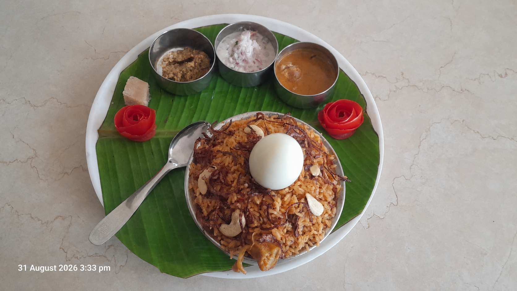 Chicken biryani with egg and side dishes served on a banana leaf in Mettupalayam